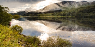 See mit Bergen im Hintergrund